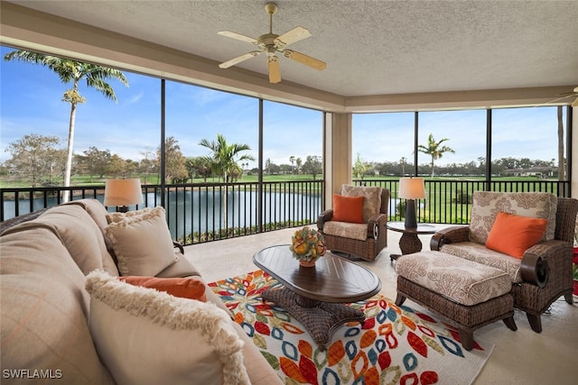 sunroom with a water view, a healthy amount of sunlight, and ceiling fan