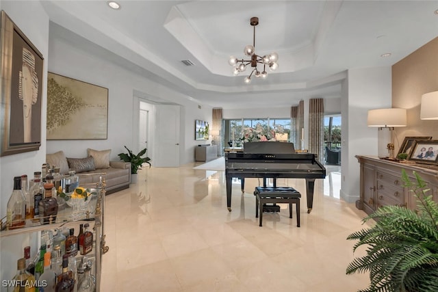 misc room featuring a raised ceiling and a chandelier