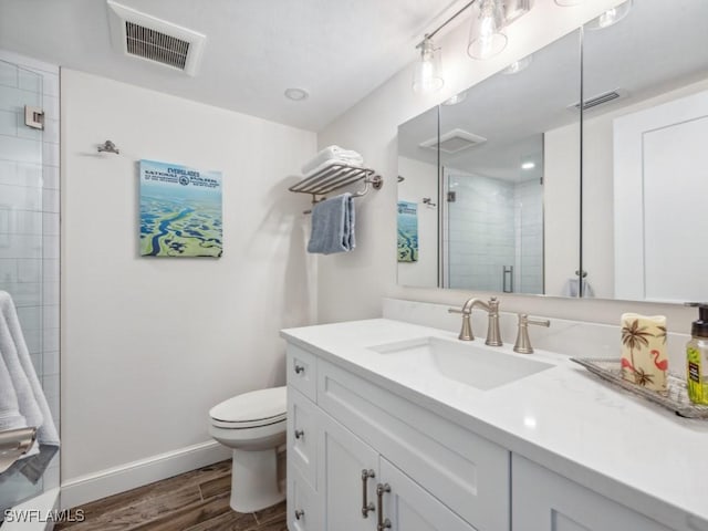 bathroom with vanity, toilet, wood-type flooring, and walk in shower