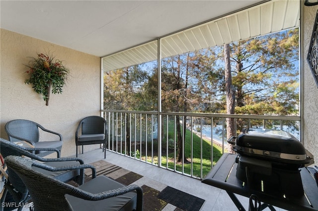 sunroom featuring a water view