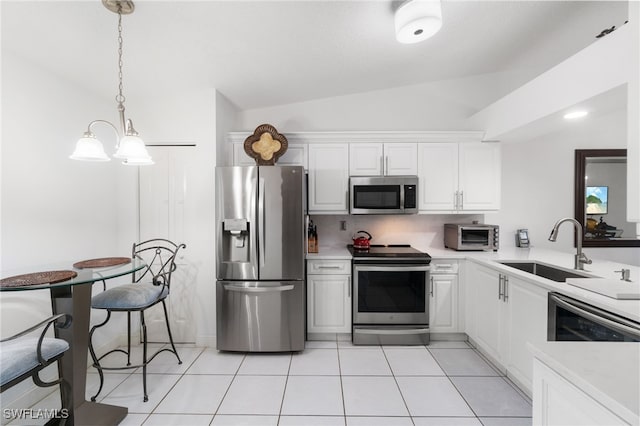 kitchen with white cabinets, hanging light fixtures, sink, vaulted ceiling, and appliances with stainless steel finishes