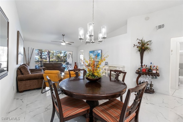 dining area featuring ceiling fan with notable chandelier and lofted ceiling