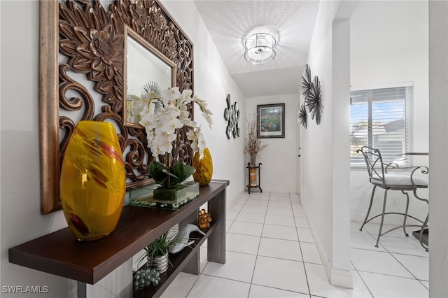 corridor featuring a textured ceiling and light tile patterned flooring