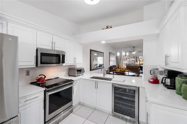 kitchen featuring white cabinets, sink, stainless steel appliances, and wine cooler