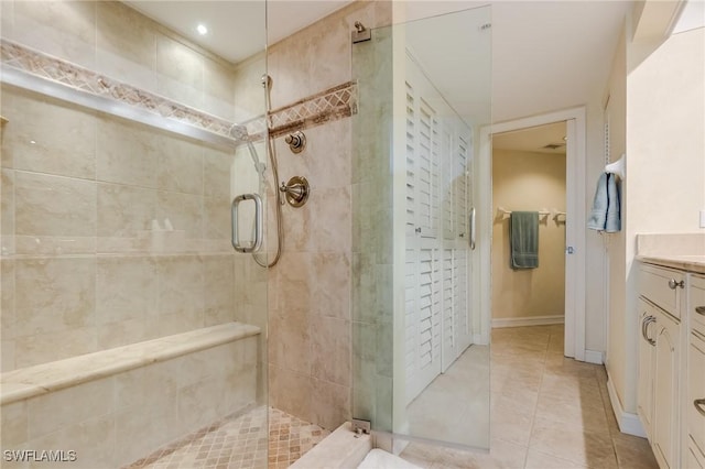 bathroom with tile patterned floors, vanity, and walk in shower