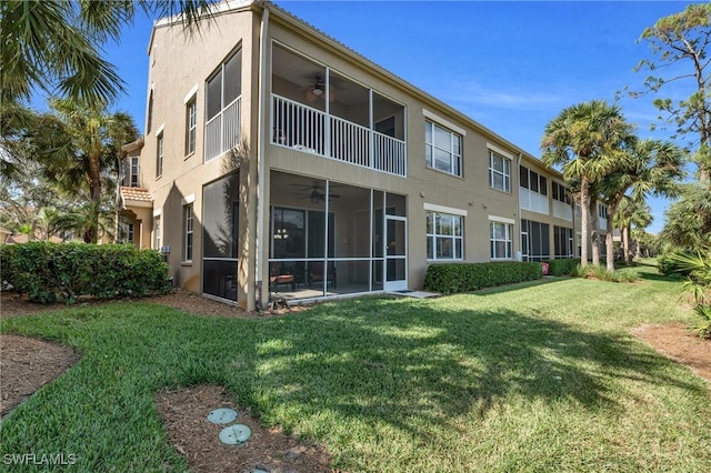 20111 Seagrove St Unit 604, Estero, FL 33928 - back of property with ceiling fan, stucco siding, a sunroom, and a lawn