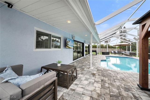 view of swimming pool with an outdoor living space, glass enclosure, and a patio