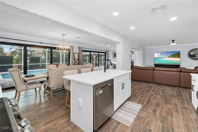 kitchen with a center island with sink, stainless steel dishwasher, sink, white cabinetry, and ornamental molding