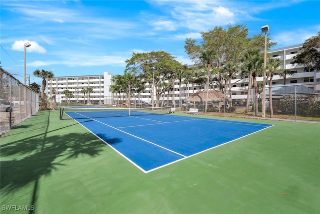 view of tennis court featuring basketball hoop