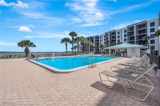 view of swimming pool with a patio and a water view