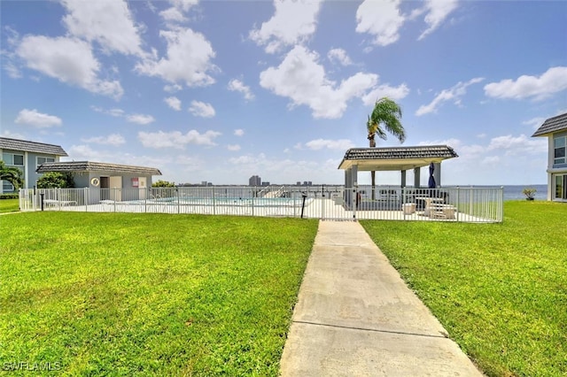 view of property's community with a swimming pool, a water view, a lawn, and a gazebo