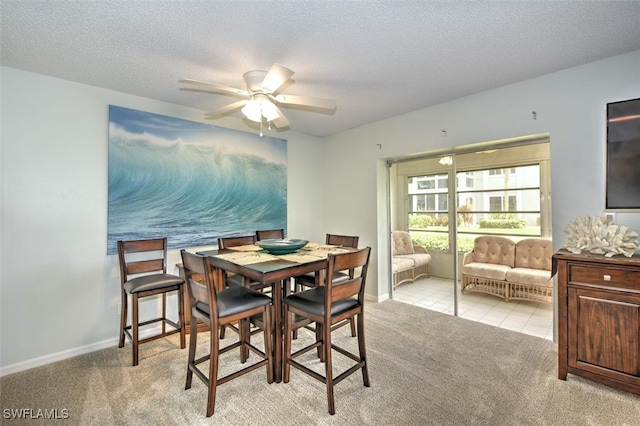 carpeted dining area featuring a textured ceiling and ceiling fan