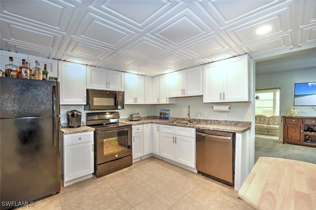 kitchen featuring white cabinets, black appliances, and light stone counters