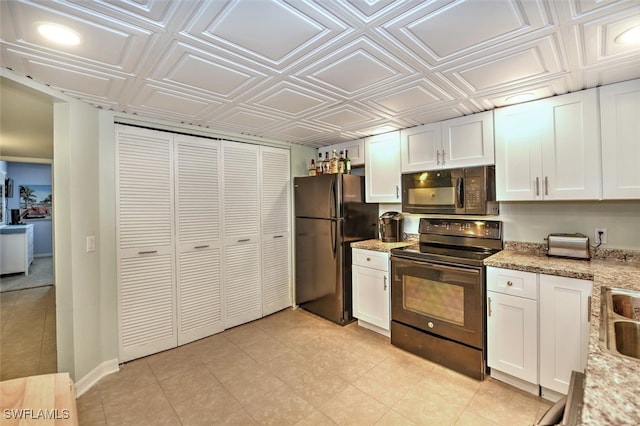 kitchen featuring white cabinets, black appliances, and light stone counters