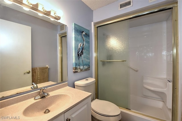 bathroom with vanity, a textured ceiling, toilet, and an enclosed shower