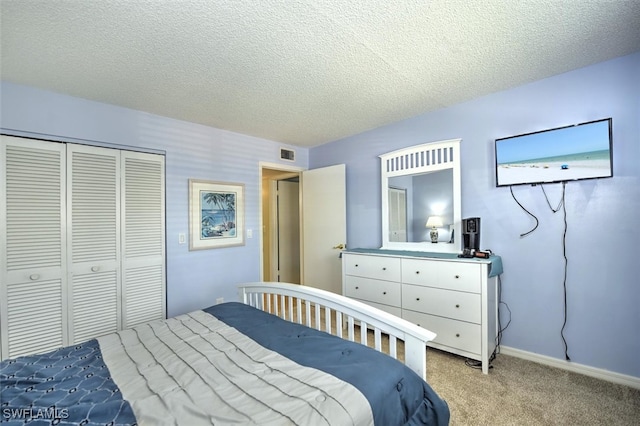 carpeted bedroom with a textured ceiling and a closet