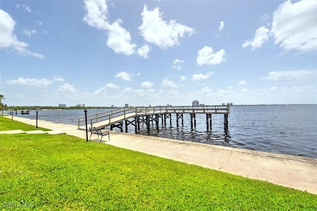 view of dock featuring a water view and a yard