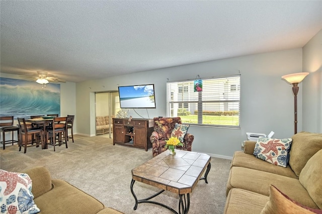 carpeted living room featuring a textured ceiling and ceiling fan