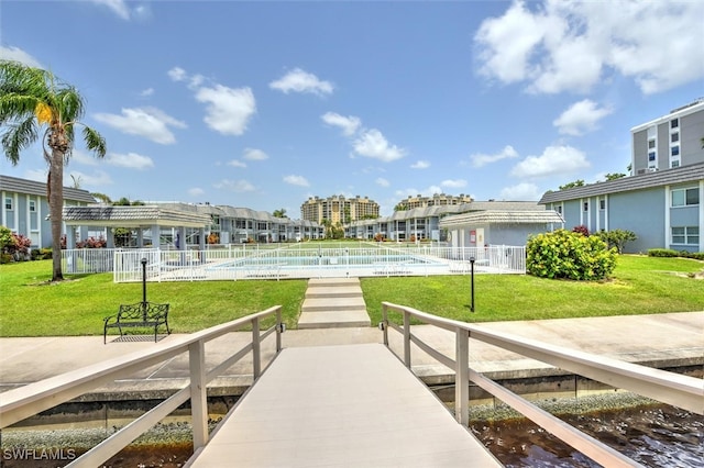 dock area featuring a lawn and a fenced in pool