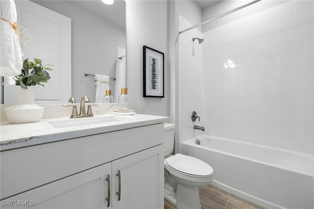 full bathroom with wood-type flooring, toilet, vanity, and tiled shower / bath