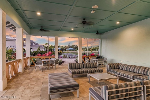 patio terrace at dusk featuring ceiling fan and an outdoor living space