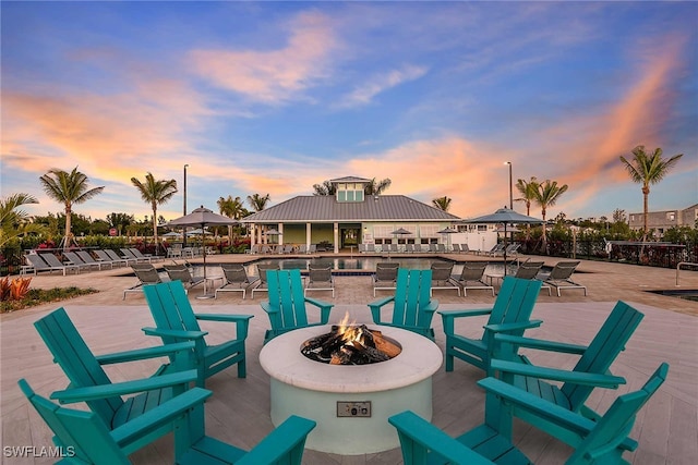 patio terrace at dusk featuring a fire pit