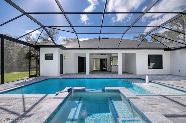 view of pool with glass enclosure, ceiling fan, a patio area, and an in ground hot tub