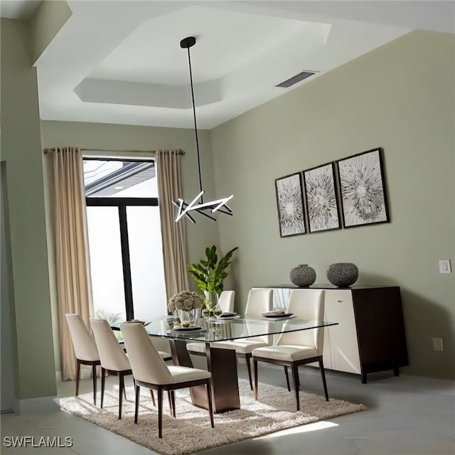 dining room with a raised ceiling