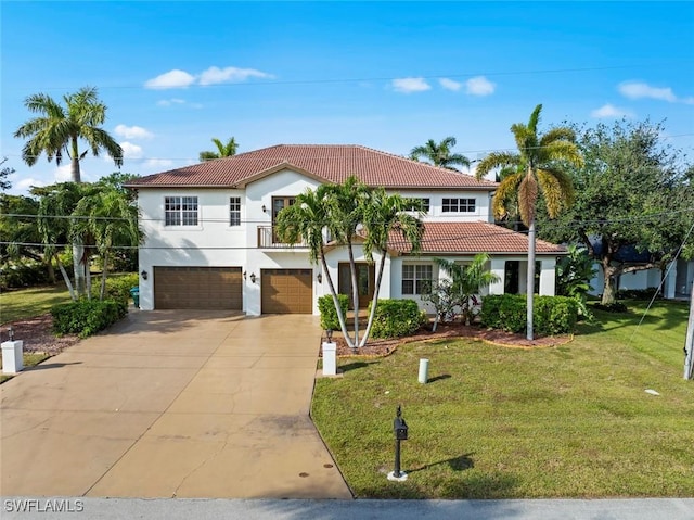 mediterranean / spanish home with a garage and a front lawn