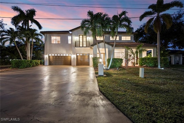 view of front of home featuring a balcony, a garage, and a lawn