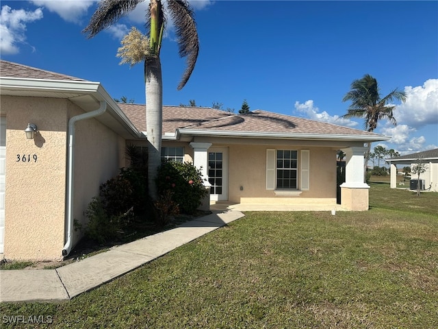 view of front of house featuring a front lawn and central AC unit