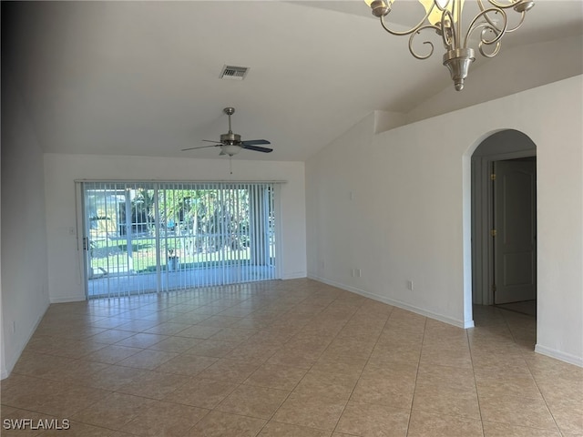 empty room with lofted ceiling, light tile patterned floors, and ceiling fan with notable chandelier