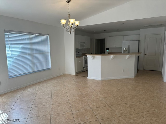 kitchen with lofted ceiling, an inviting chandelier, hanging light fixtures, a breakfast bar, and white appliances