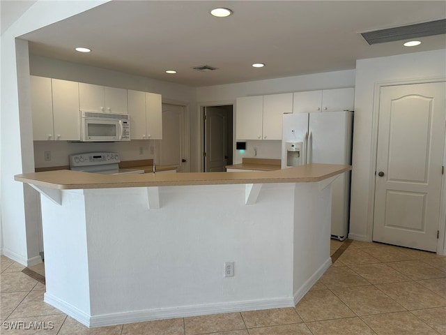 kitchen with white cabinets, a center island with sink, white appliances, and light tile patterned floors