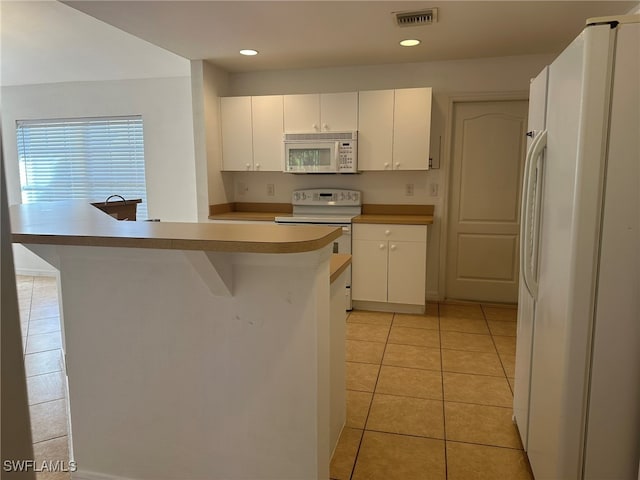 kitchen with white cabinetry, white appliances, and light tile patterned flooring