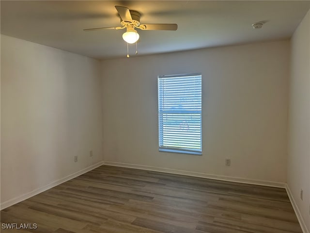 empty room with ceiling fan and dark hardwood / wood-style flooring