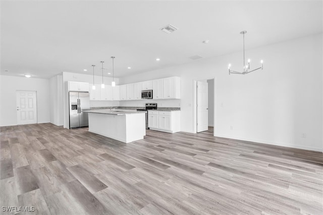 kitchen with white cabinets, decorative light fixtures, stainless steel appliances, and light hardwood / wood-style floors