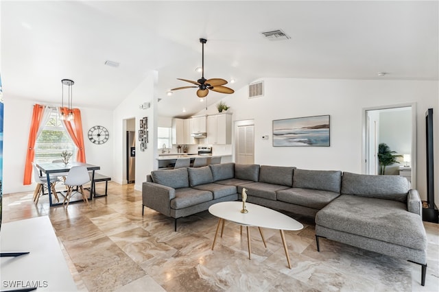 living room featuring ceiling fan, sink, and vaulted ceiling