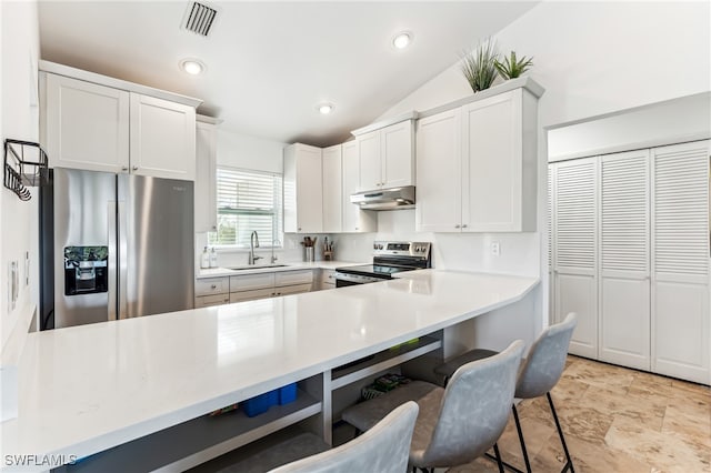 kitchen with stainless steel appliances, white cabinets, sink, and vaulted ceiling