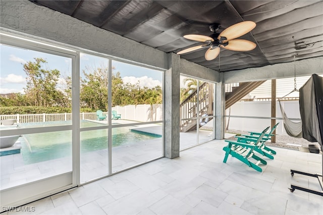 unfurnished sunroom with ceiling fan and plenty of natural light