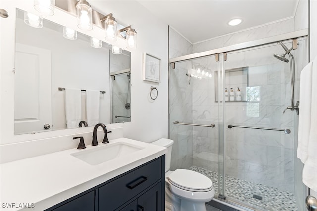 bathroom with a shower with door, vanity, and toilet