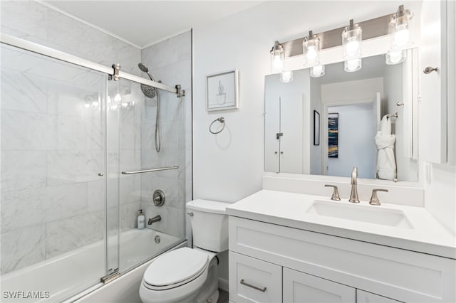 full bathroom featuring bath / shower combo with glass door, vanity, and toilet