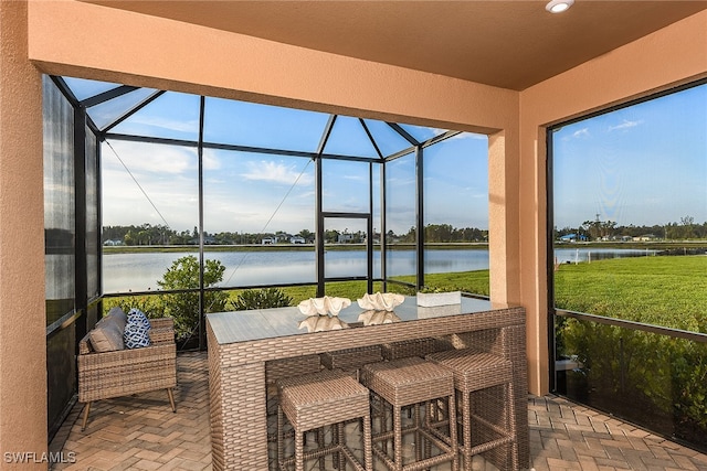 sunroom / solarium featuring a water view