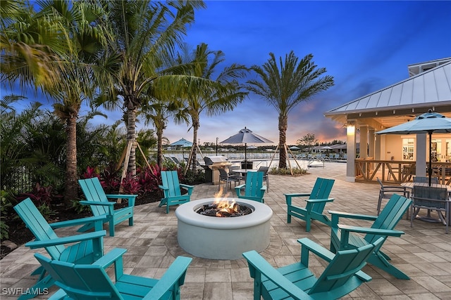 patio terrace at dusk featuring an outdoor fire pit