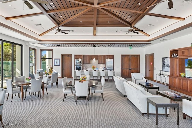 living room with light carpet, coffered ceiling, ceiling fan, and a high ceiling