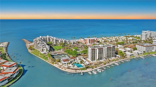 aerial view at dusk featuring a water view