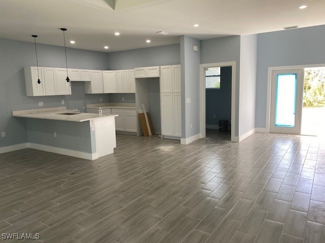 kitchen featuring plenty of natural light, pendant lighting, dark hardwood / wood-style floors, and white cabinets