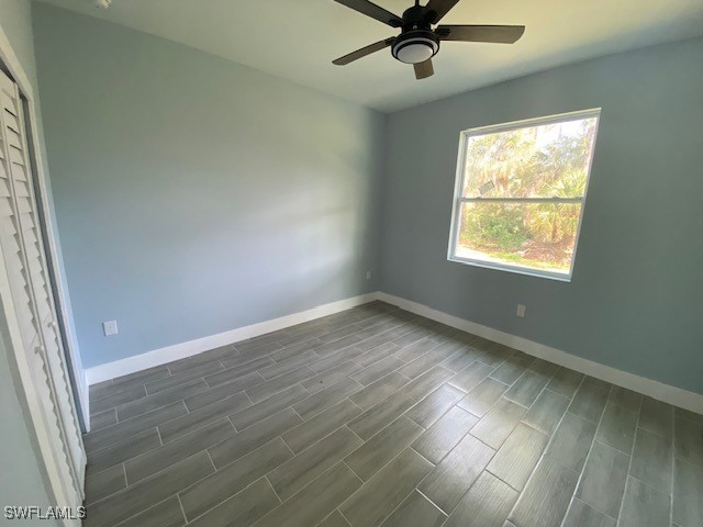 empty room featuring dark hardwood / wood-style flooring and ceiling fan