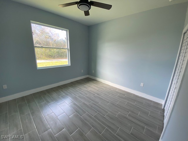 unfurnished room with dark hardwood / wood-style floors and ceiling fan