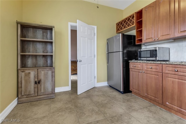 kitchen with stainless steel appliances, light tile patterned floors, and backsplash